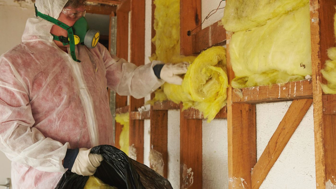 Old insulation being safely removed from a New Zealand ceiling